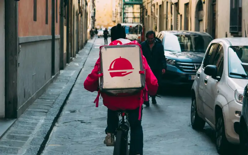Courier collecting takeaway and delivery orders tracked through the order management system